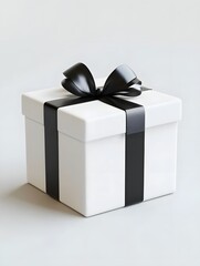 Fototapeta premium A simple white gift box with a black ribbon and bow, symbolizing celebration and giving.