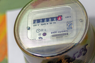 The face of an Electromechanical induction counter mounted on the wall of the room. close up.