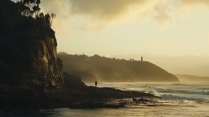 Solitary figure on coastal cliff at sunset, ocean waves.