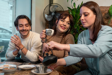 Group of friends enjoying tea and conversation at cozy cafe