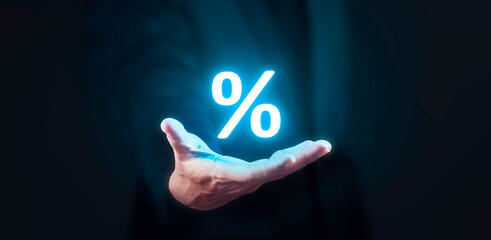 Man holding blue glowing percentage icon. Finance and mortgage interest rate concept.