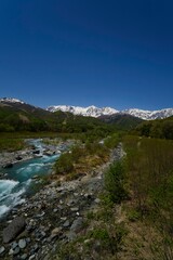 雪山と清流 – 青空の下で輝く大自然