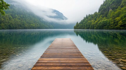 Fototapeta premium Serene Wooden Dock Overlooking Tranquil Misty Mountain Lake