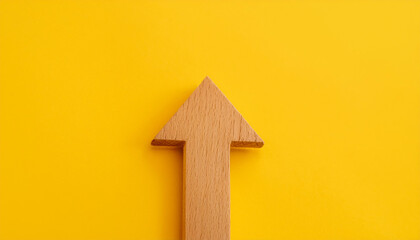 Minimalist wooden arrow on yellow background. Wood pointer, forward direction, up.