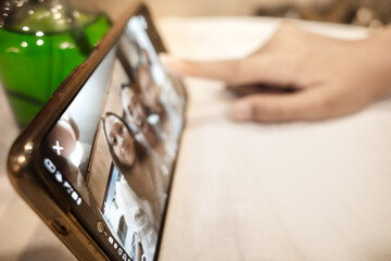 Person hand touching smartphone screen to start video call with family