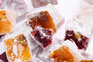 Sweet food Turkish delight, assorted rahat locum in form of cubes with nuts and powdered sugar, traditional food, on white background