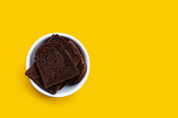 Dark cocoa bread on yellow background.