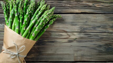 Fresh green asparagus bunch on rustic wood.