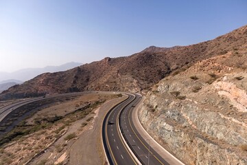 Aerial view of a highway between rocky mountains and blue sky in Taif city, Saudi Arabia