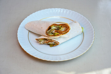 Cig kofte (raw meatball) with lettuce, tomato, pickle and lemon, hot Chee kofta. Turkish local raw food concept.Table scene of assorted take out or delivery foods. Doritoslu duble cig kofte durum.