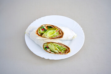 Cig kofte (raw meatball) with lettuce, tomato, pickle and lemon, hot Chee kofta. Turkish local raw food concept.Table scene of assorted take out or delivery foods. Doritoslu duble cig kofte durum.