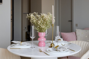 An Elegant Dining Setup Featuring a Delightful Pink Vase Accompanied by White Flowers