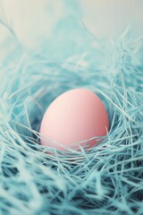 Pinkes Osterei eingebettet in ein leuchtend blaues Nest