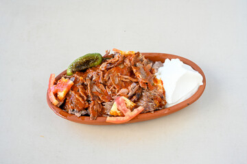 Turkish  Traditional Ramadan doner kebab with tasty tomato sauce and rice or turkish pilav in white plate on table background. Lavash doner kebab ( doner zurna durum )  Pilavustu Doner Iskender kebap