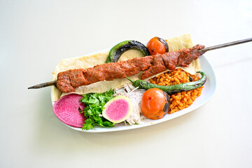 Famous Urfa meat liver, ciger wrapped by lavash with roasted chili pepper, onion and sauce in...