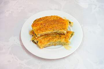 Turkish style meat stuffed filo dough borek served kol boregi.Cheese and minced pie are sliced on a marble background. Turkish name: Kol Boregi, kiymali, peynirli su boregi. Ci borek. Kafkas cig borek