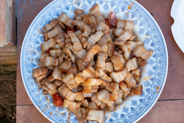 Preparing La Mancha or Castilian migas as a family where everyone eats with a spoon from the same pot. we can appreciate all its ingredients, chistorra, bacon, bread, pepper...