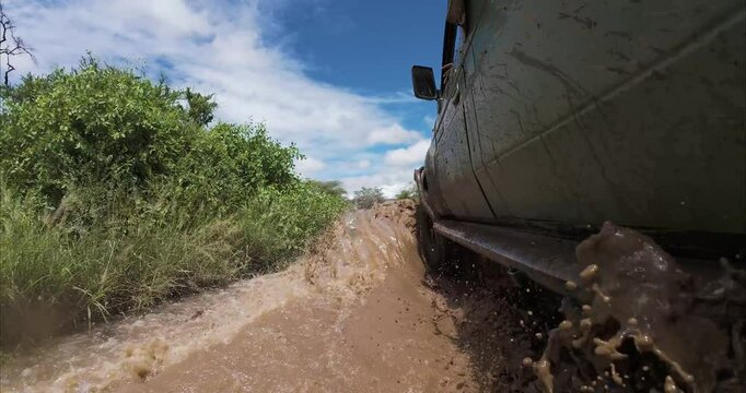 A 4x4 or safari car drives through flooded roads