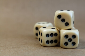Dice on beige background with shallow depth of field and copy space