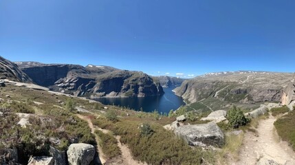 Panoramic view of a fjord surrounded by mountains and trails.