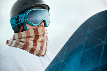 Ski Goggles Of Snowboarder With The Reflection Of Snowed Mountains. Winter Sports. Portrait Of Woman On The Background Of Mountains and Sunset