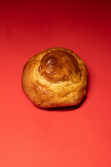 Golden Brioche Roll on Vibrant Red Background