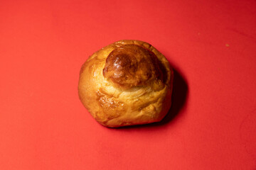 Golden Brioche Roll on Vibrant Red Background