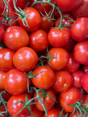 Red bright tomatoes at the market symbolize healthy eating. Organic and fresh tomatoes, just picked and ready to sell or eat. Images of vegetable products
