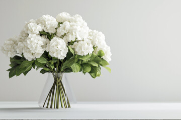 Naklejka premium A minimalist wedding bouquet made entirely of white hydrangeas on a light gray background.