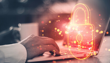 Digital padlock hologram overlaying a person typing on a laptop, symbolizing cybersecurity and online data protection.