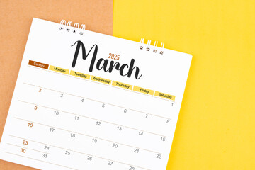 March 2025 desk calendar on brown and yellow, Planning for business.