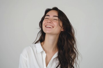 Beautiful brunette woman smiling confidently in casual attire.