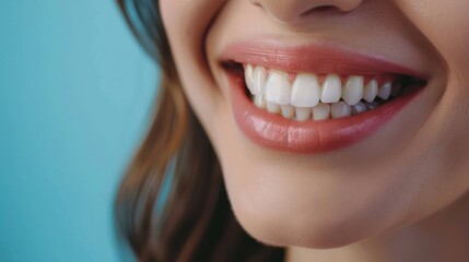 Smiling woman shows perfect white teeth and glossy pink lips against a blue background.