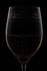 Macro shot of Champagne sparkling in a wine glass, background is blurred.