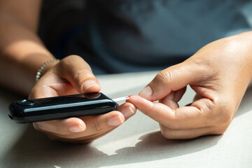 hand of people check diabetes and high blood glucose monitor with digital pressure gauge. Healthcare and Medical concept	