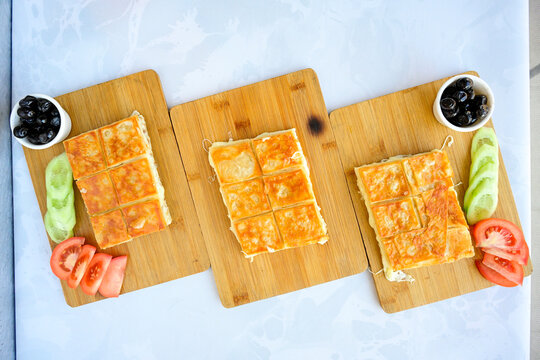Turkish style meat stuffed filo dough borek served kol boregi.Cheese and minced pie are sliced on a marble background. Turkish name: Kol Boregi, kiymali, peynirli su boregi. Ci borek. Kafkas cig borek