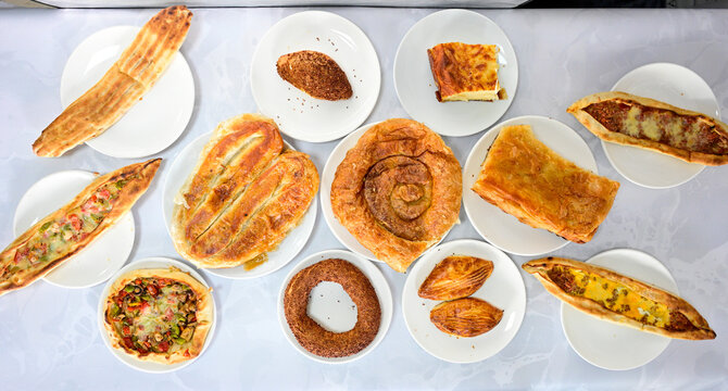 Turkish style meat stuffed filo dough borek served kol boregi.Cheese and minced pie are sliced on a marble background. Turkish name: Kol Boregi, kiymali, peynirli su boregi. Ci borek. Kafkas cig borek
