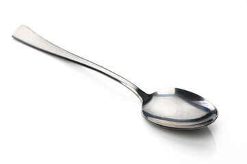 Shiny silver spoon resting on a smooth white surface, glistening under soft light