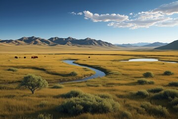 Obraz premium grassy plain with a stream running through it and mountains in the distance