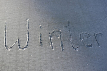 gefrorener Untergrund mit dem Schriftzug Winter 