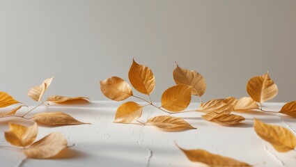 Fototapeta premium A group of golden leaves arranged on a white surface