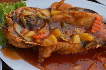 A classic sweet and sour fish dish features crispy fried fish topped with a vibrant sauce made from...