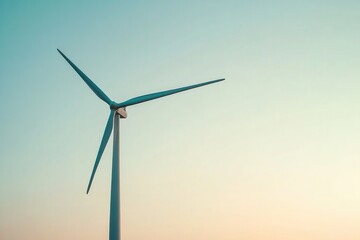 Fototapeta premium Tall wind turbine against pastel sky, symbolizing renewable ener