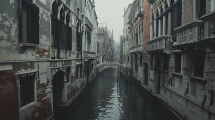 Fototapeta premium Foggy canal with bridge & old buildings.