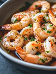 A creamy garlic sauce bathes these cooked shrimps, topped with fresh herbs. A delicious and hearty seafood dish.