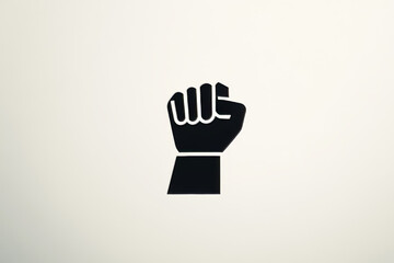 Obraz premium A powerful black fist is raised against a light background, representing unity and strength in various social justice movements. This emblem embodies the call for change and equality