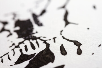 Extreme close up of black acrylic paint texture on paper. Selective focus.