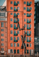red brick building with windows and cranes