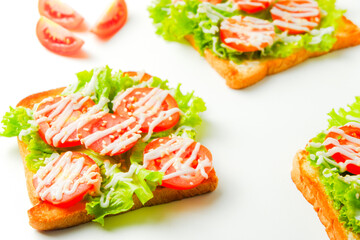 Colorful toast healthy sandwich with green lettuce and red tomato isolated on white background