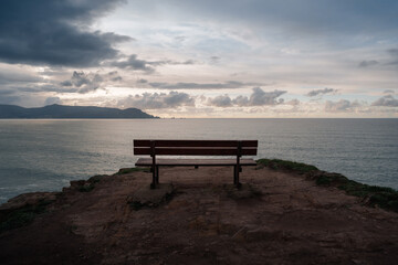 A peaceful bench overlooking the Atlantic Ocean at sunset in Loiba, Galicia